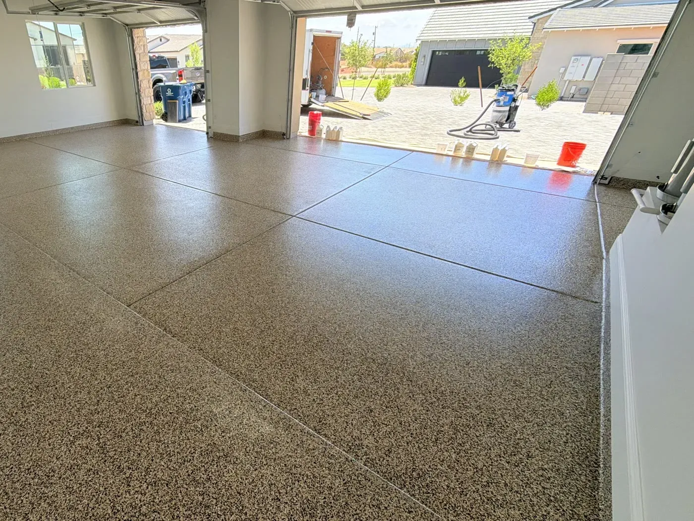 Garage floor finished with a full flake coating in the Chestnut blend, with the garage doors open